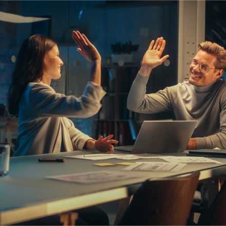 Pracownicy przybijający sobie piątkę