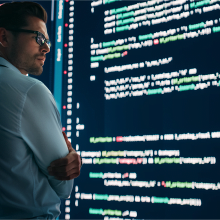 Programista patrzący na kod na monitorze