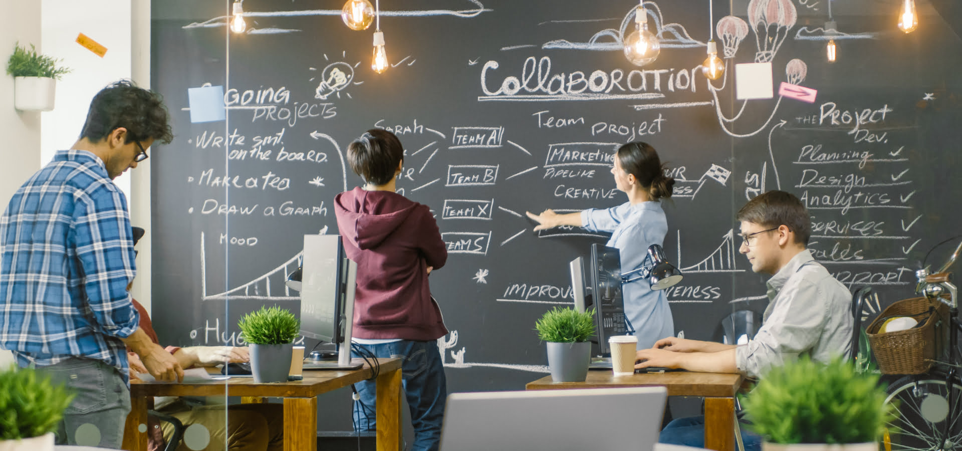 Pracownicy omawiają wymagania projektu przy tablicy